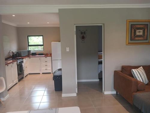 a living room with a couch and a kitchen at Ledges Retreat in Bergville