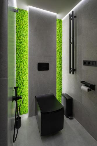 a bathroom with a green wall and a stool at Born to travel apartment in Chernivtsi