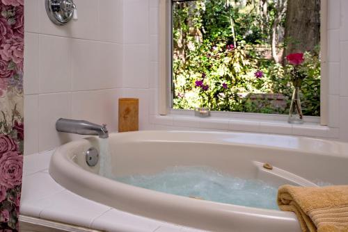 une baignoire avec une fenêtre dans une salle de bain dans l'établissement Magnolia Plantation & Cottages, à Gainesville