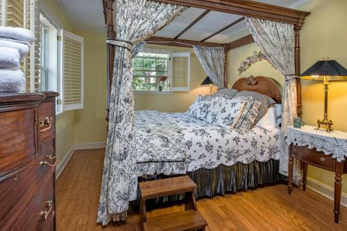 une chambre avec un lit à baldaquin et une fenêtre dans l'établissement Magnolia Plantation & Cottages, à Gainesville