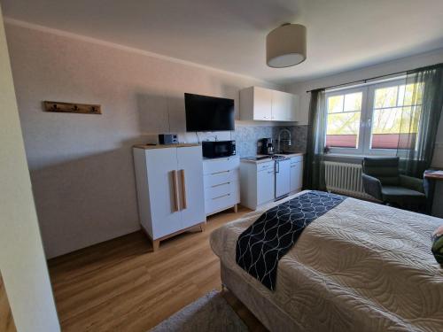 TeschendorfHaus-Fehmarn-am-Dorfteich-|-Wohnung-3-Nord的酒店客房设有一张床和厨房