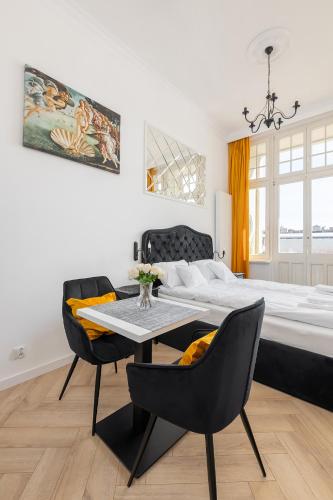 a bedroom with a bed and a table and chairs at Loggia Apartments in Poznań