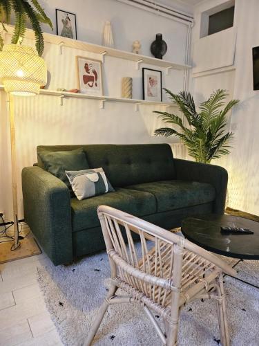 a living room with a green couch and a table at Havre de Paix - Les Sablon d'A Côté in Amiens