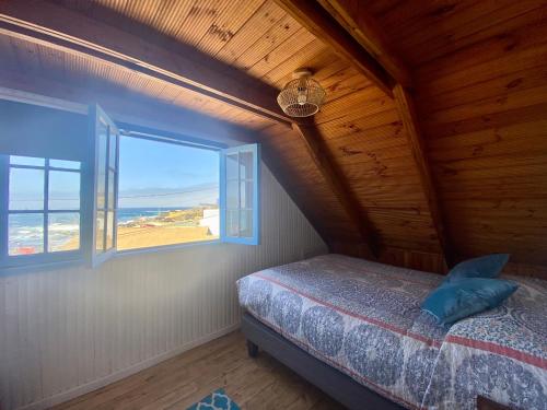 a bedroom with a bed and a window at Hostal Casa La Puntilla in Los Molles