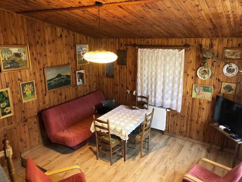 a living room with a table and a red couch at Moja Stay - wyjątkowy dom z sauną in Niesulice