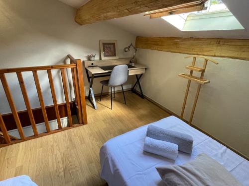 une chambre avec un lit, un bureau et une table dans l'établissement Gîte l'Olivier, à Bollène
