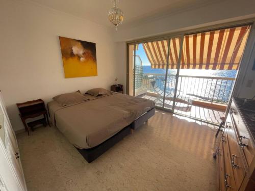 une chambre avec un lit et une vue sur un balcon dans l'établissement Verseau vue mer et Rocher de Monaco, à Cap d'Ail