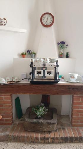 a machine sitting on a table with a clock on the wall at B&B il Palazzo Cirella in Cirella