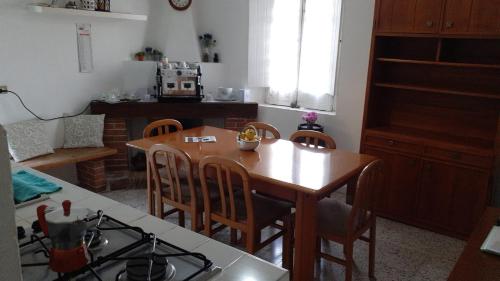 a kitchen with a wooden table and a table and chairs at B&B il Palazzo Cirella in Cirella