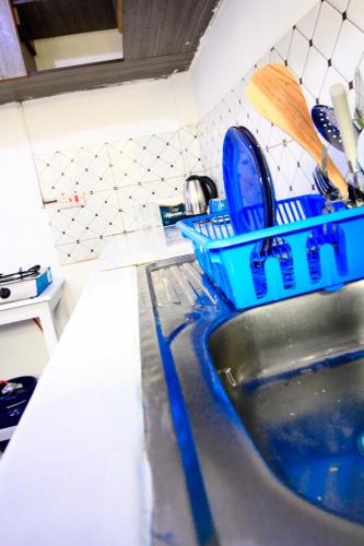 a kitchen sink with a blue dish rack on it at D&A Homes in Eldoret