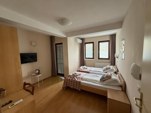 a bedroom with a bed and a room with a tv at Villa Lucija in Ohrid