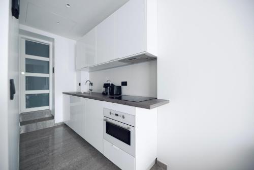 une cuisine blanche avec une cuisinière et un évier dans l'établissement Mediterranean Cosy Studio, à Cannes