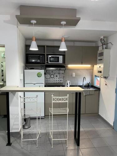 a kitchen with a counter and two stools in it at Dilans in San Luis