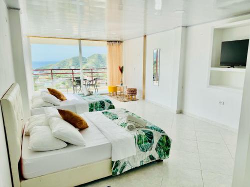 zwei Betten in einem Zimmer mit Balkon in der Unterkunft Casa Relax - Adults Only in Taganga