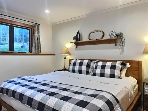 a bedroom with a black and white checkered bed at CozyDen - AC, Grill, Bike to Mountain, Porch! in Killington