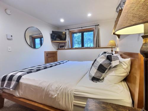 a bedroom with a bed and a mirror at CozyDen - AC, Grill, Bike to Mountain, Porch! in Killington