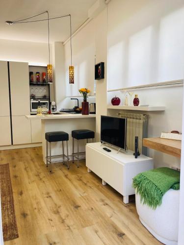 a kitchen and living room with a desk and a tv at City Garden Loft in Pescara