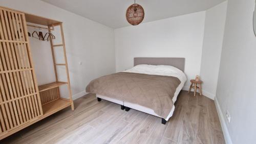 a bedroom with a bed and a wooden floor at Belle Plage in Blankenberge
