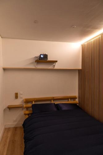 a bedroom with a bed with a camera on a shelf at Appartement jungle in Moulins
