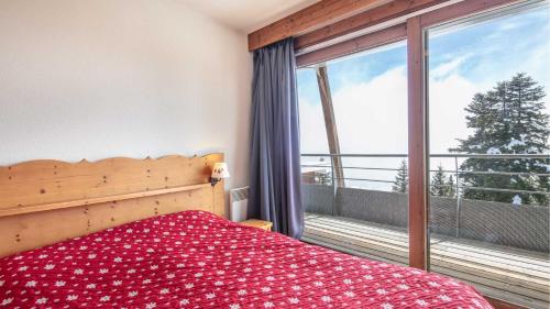 une chambre avec un lit et une grande fenêtre dans l'établissement V du Bachat Arolles A n26 - 2P4, à Chamrousse