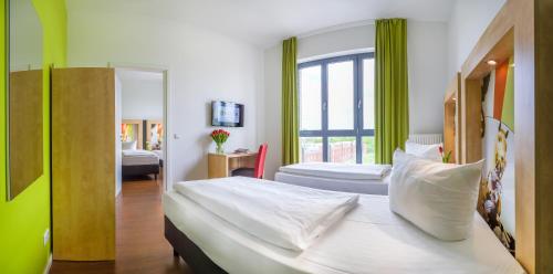 a hotel room with two beds and a window at H+ Hotel 4Youth in Berlin