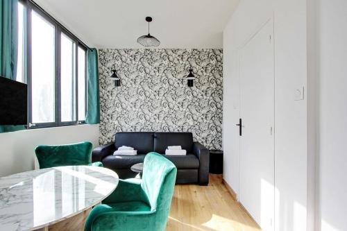 - un salon avec une table en verre et des chaises vertes dans l'établissement Cosy studio - 2P - Parc de Belleville, à Paris