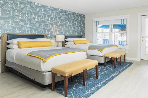 a bedroom with two beds and a blue rug at Danfords Hotel & Marina in Port Jefferson Station