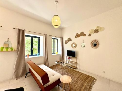 a living room with a couch and a table at Studio Boho, 4 personnes Nîmes, Lit 160 + CLIM in Nîmes