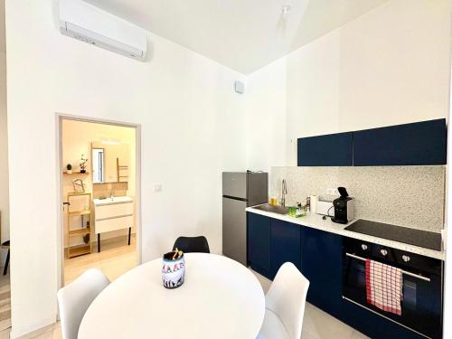 - une cuisine avec une table blanche et des chaises blanches dans l'établissement Studio Boho, 4 personnes Nîmes, Lit 160 + CLIM, à Nîmes