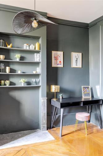 un bureau noir avec un tabouret rose dans une pièce dans l'établissement Nancy Vieille ville Stanislas, à Nancy