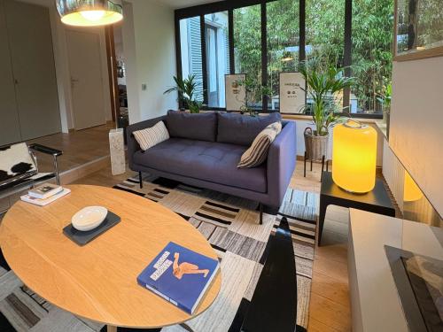 un salon avec un canapé et une table dans l'établissement Villa à Louveciennes, à Louveciennes