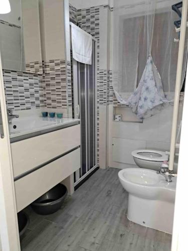 a white bathroom with a toilet and a sink at Antema in Scario