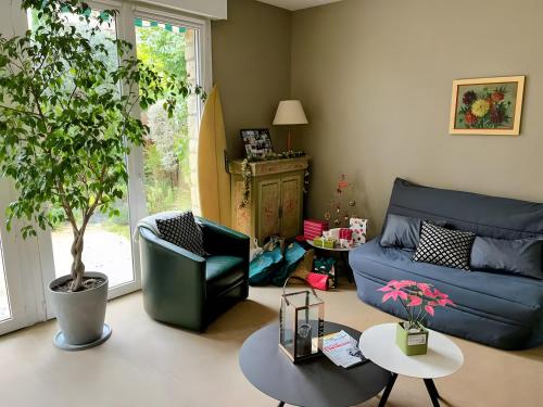 a living room with a blue couch and a table at Appartement 90m2 Sur Jardin Clos in Saint-Cloud