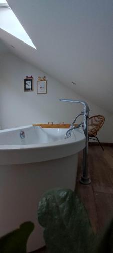 - une baignoire dans une chambre avec une chaise dans l'établissement Villa familiale proche centre, à Bourges
