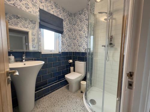 a bathroom with a toilet and a sink and a shower at House Sleeps 8-Garden-Parking Near Barry Island in Flemingston