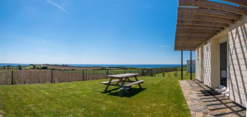 a picnic table in the grass next to a building at The house of the guardians of the Ocean with spa - gite plougonvelin in Plougonvelin