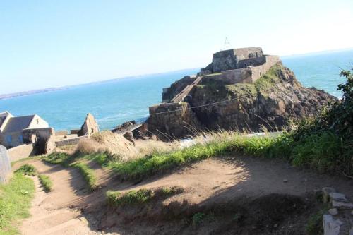 a dirt path leading up to a rock formation on the ocean at The house of the guardians of the Ocean with spa - gite plougonvelin in Plougonvelin