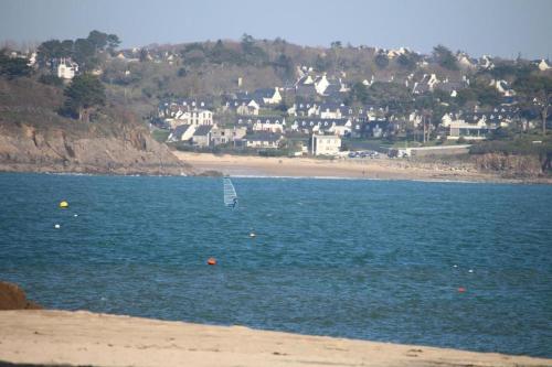 a sail boat in the water near a beach at The house of the guardians of the Ocean with spa - gite plougonvelin in Plougonvelin
