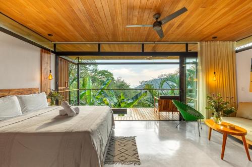 a bedroom with a large bed and a balcony at The Green House, Santa Teresa - Adults Only in Santa Teresa Beach