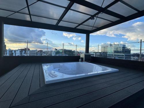 a large bath tub in a room with a large window at Comfort and style in Bogotá in Bogotá