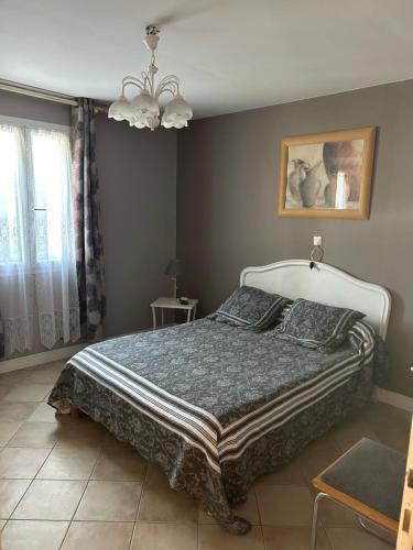 une chambre avec un lit et un lustre dans l'établissement Maison en pierre 6 personnes, à Montaut