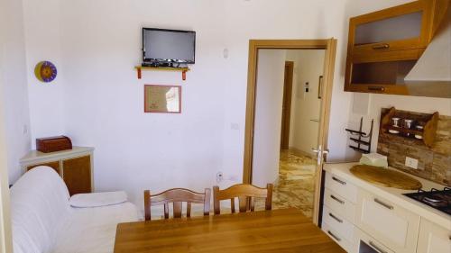 a room with a bed and a table and a kitchen at casa vacanze in villa in San Donaci