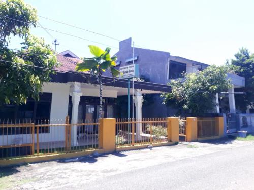 a building with a fence in front of a street at Wisma Syariah Rumah Bundo in Padang