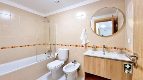 a bathroom with a toilet and a sink and a mirror at Pestana Green View in Caniço