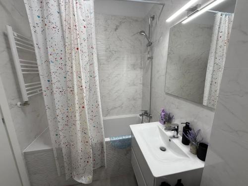 a white bathroom with a sink and a shower curtain at Primavera Pipera Plaza in Voluntari