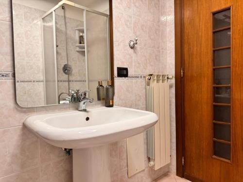a bathroom with a white sink and a mirror at La Rosa di Pompei in Scafati
