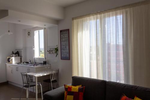 Una sala de estar con un sofá y una mesa y una cocina. en Cuore Flat, en Módica