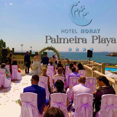 a group of people sitting in chairs at a wedding on the beach at Hotel Norat Palmeira Playa in Ribeira