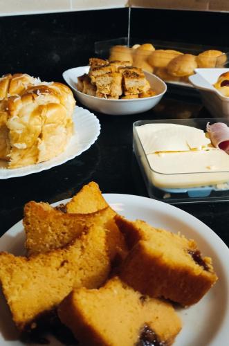 a table topped with plates of bread and other desserts at Hotel Hellyus in Brasilia