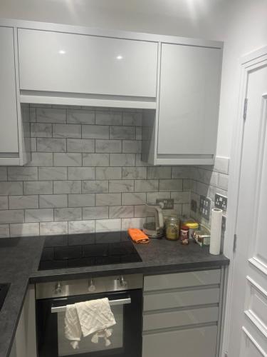 a kitchen with a stove and white cabinets at QB Stylish 2 Bedroom Apartment - Smart TV - Wifi - Parking in West Thurrock
